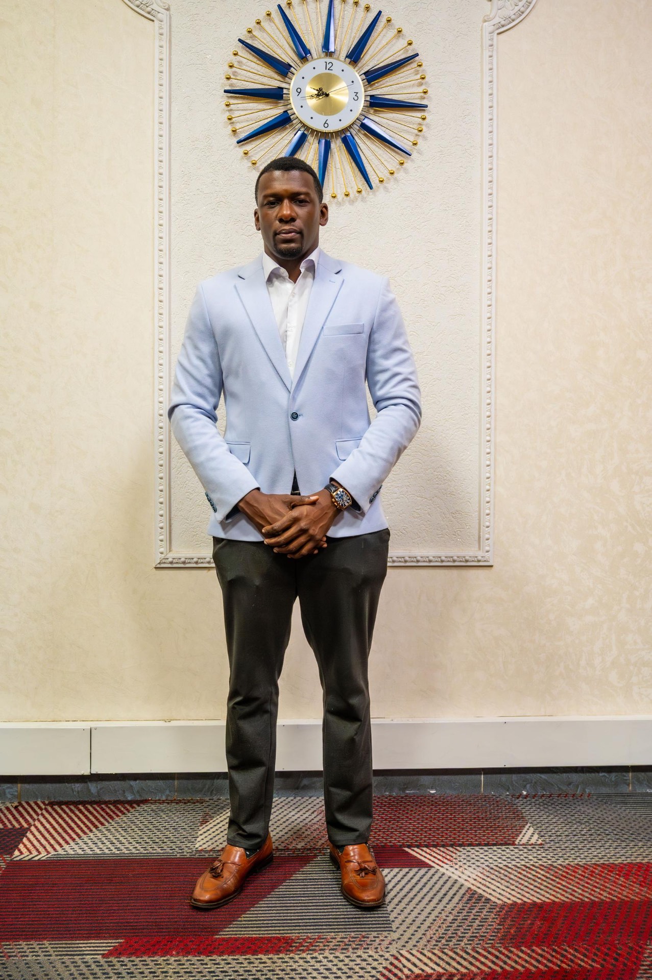 Bidemi Okorodudu standing full length in a tailored light blue blazer